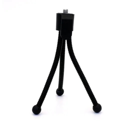 Small black iron mini tripod with ball head, shown collapsed to 110mm and extended on a desktop next to a smartphone.