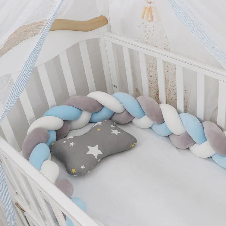 Bendable braid knot baby crib bumper in spandex velvet fabric on a white cot.