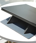 Blue portable laptop cooling bracket with foldable design on a wooden table.