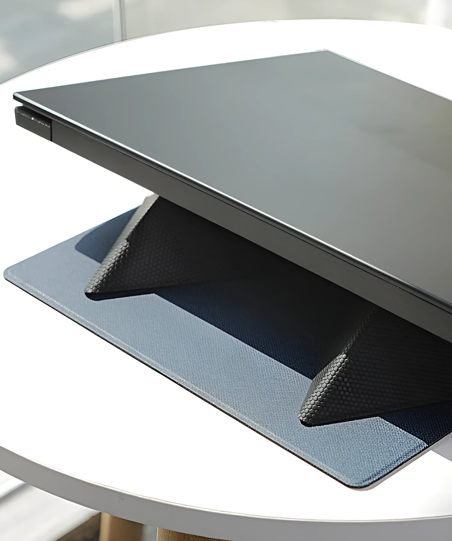 Blue portable laptop cooling bracket with foldable design on a wooden table.