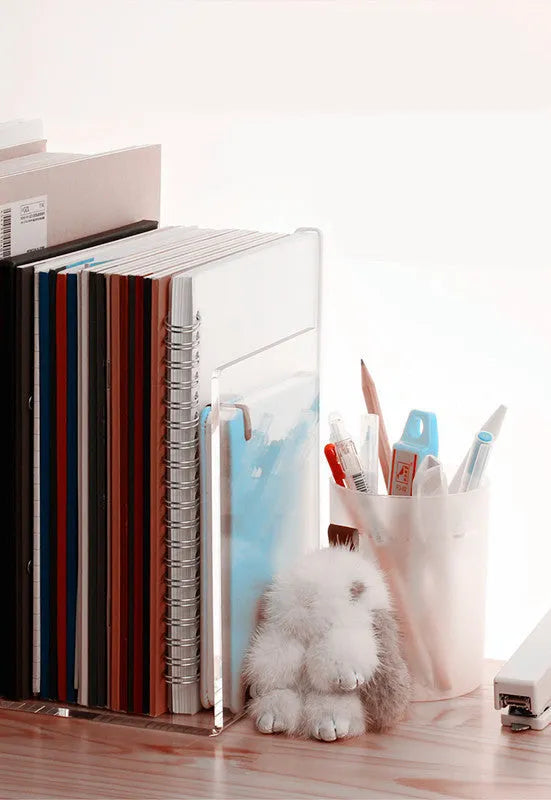 Transparent acrylic bookshelf displaying books on desk with smooth polished edges