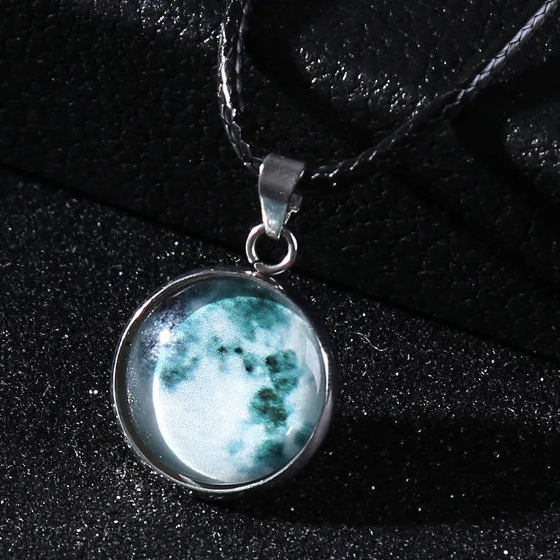 Luminous moon and constellation glass pendant on a silver alloy necklace chain with an extension piece.
