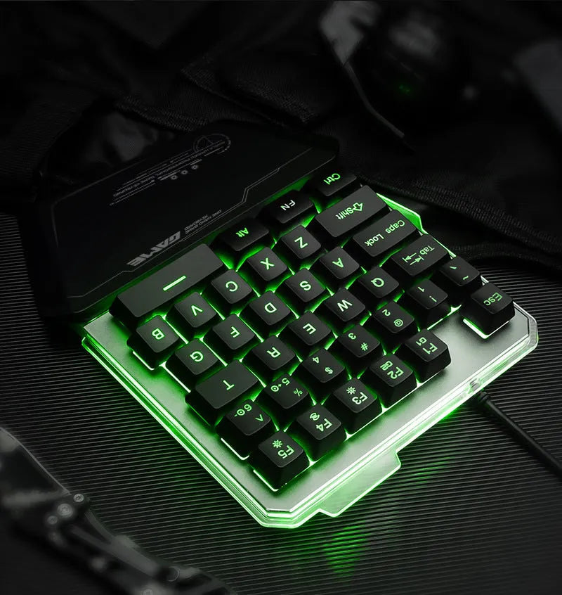 Black robotic one-handed mechanical keyboard with RGB backlit keys on a desk.