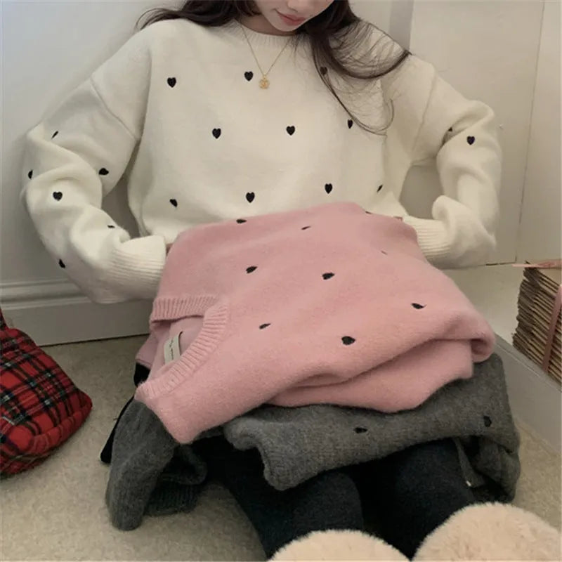 Women's loose grey acrylic pullover sweater with embroidery on the front.