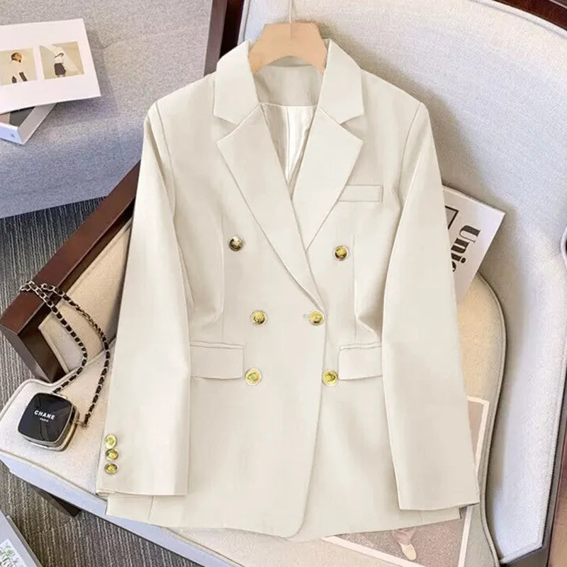 Women's loose fit polyester blouse and matching trousers in beige, shown on a hanger.