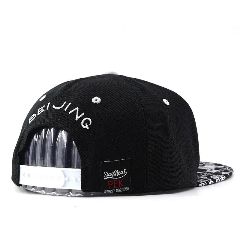 Black and white cotton baseball cap with embroidered letter design on the front.