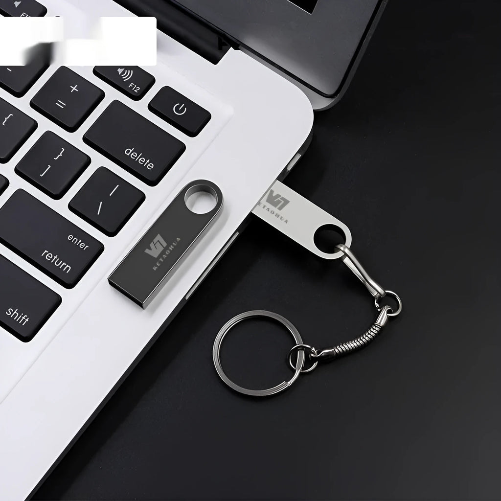 Silver metal car-shaped USB flash drive on a white background, showing its compact size and USB connector.