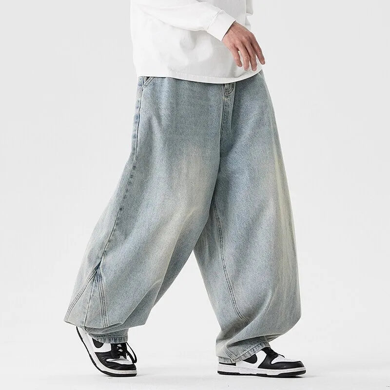 Men's plus size baggy blue denim jeans with a straight leg and low waist on a hanger.