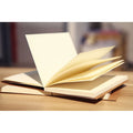 Brown kraft paper sketchbook with wireless binding open to show drawing pages