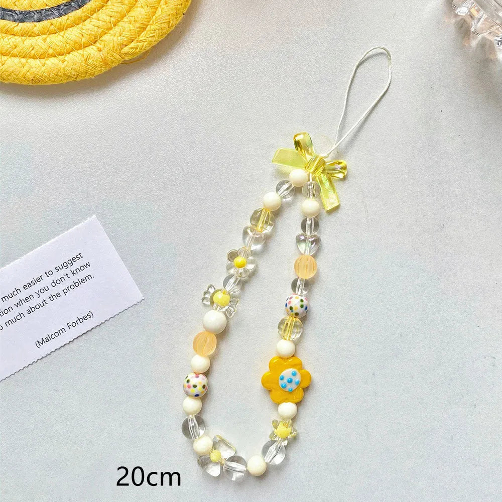 Colourful beaded mobile phone lanyard with a blue resin flower charm on a hand strap.