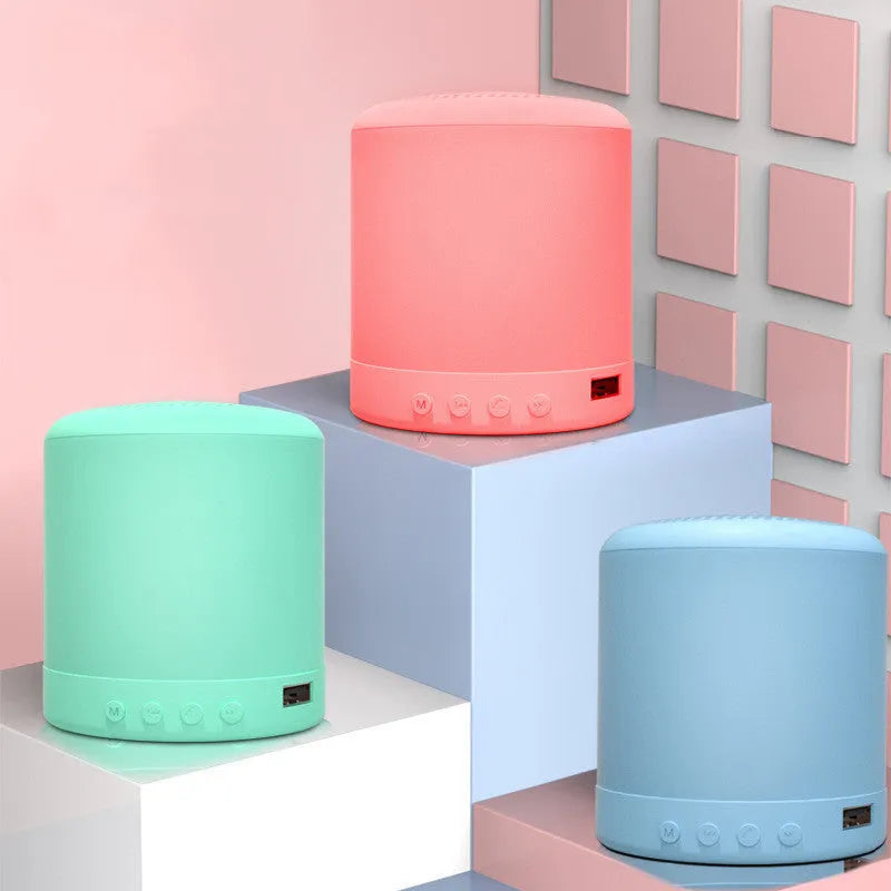 Small A11 wireless stereo speaker in black, pink, blue, or green colours on a surface.