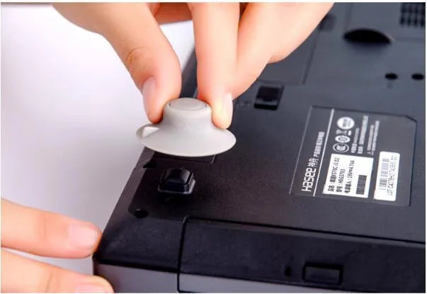 Set of four grey plastic laptop cooling pads, two large and two small, on a desk.