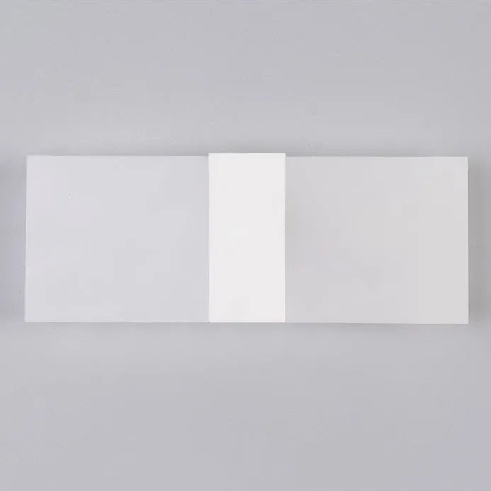 Modern black acrylic LED wall lamp with warm white light on a corridor wall.