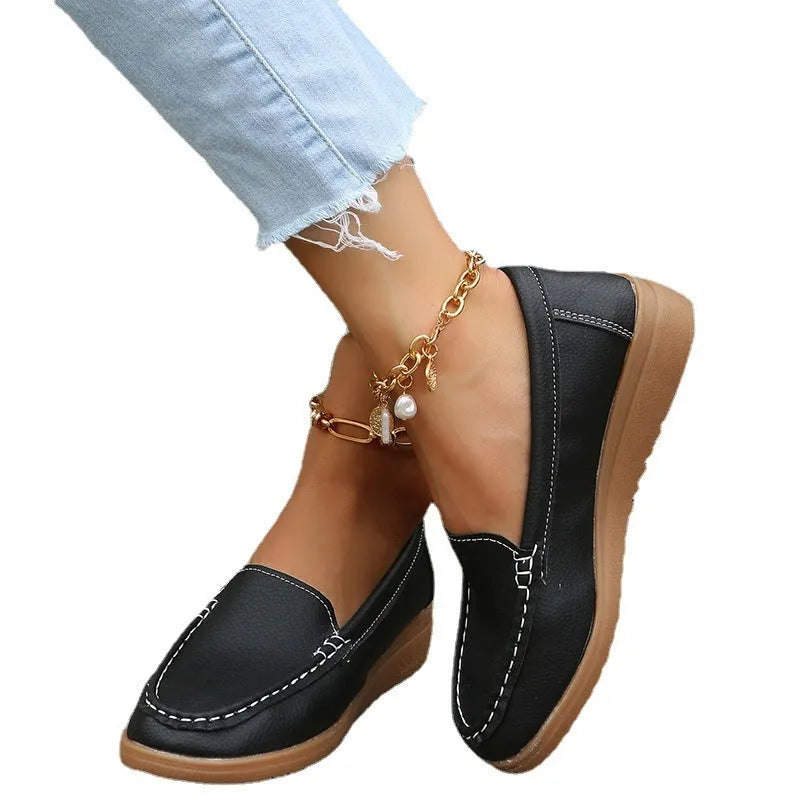 Women's black PU leather flat loafers with round toe and car suture detail on a white background.