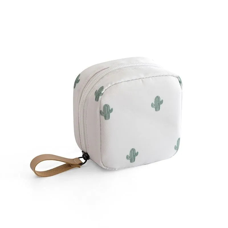 A blue cube-shaped cloth makeup storage bag sitting on a surface, open to show interior space.