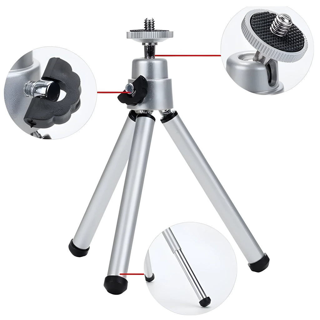 Black mini flexible tripod extended on a table with a silver U-shaped phone clip attached.
