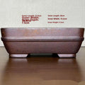 Light brown rectangular ceramic bonsai flower pot on a wooden surface