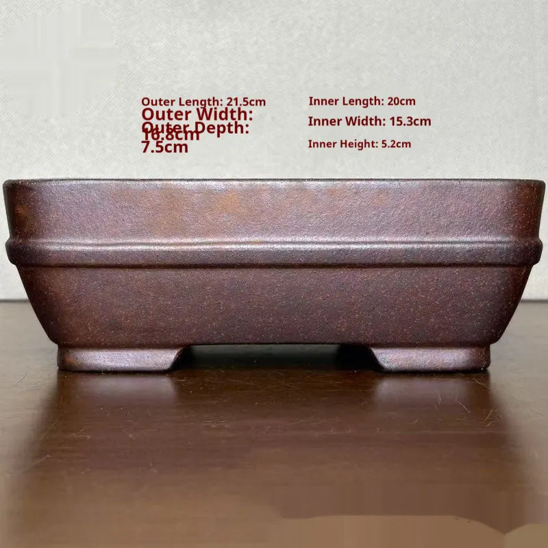 Light brown rectangular ceramic bonsai flower pot on a wooden surface
