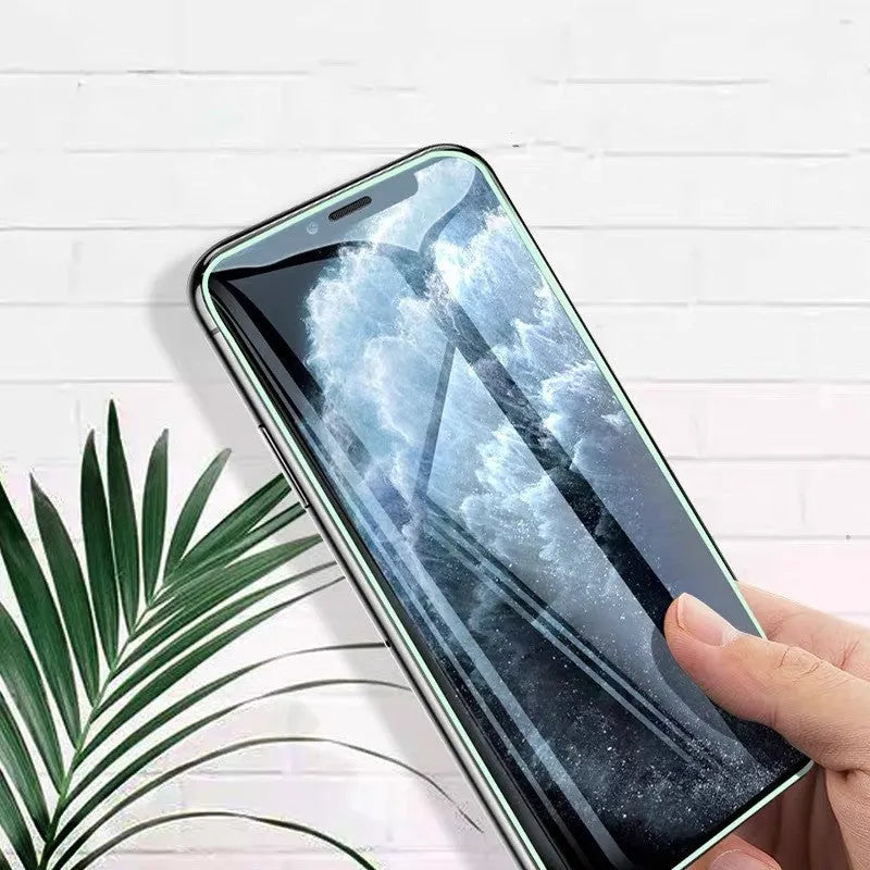 Luminous full cover tempered glass screen protector for iPhone glowing in dark on a phone.