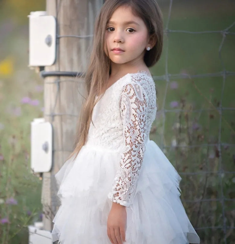 White long-sleeved lace princess dress for girls with an irregular hemline, shown on a hanger.