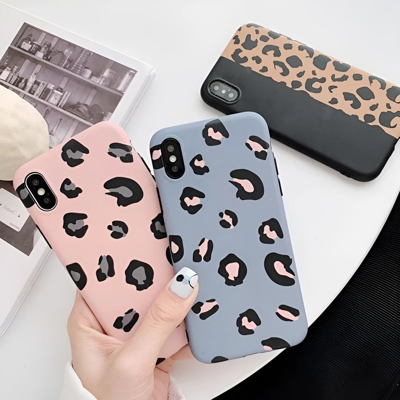 Leopard print pattern phone case for iPhone models on a table.