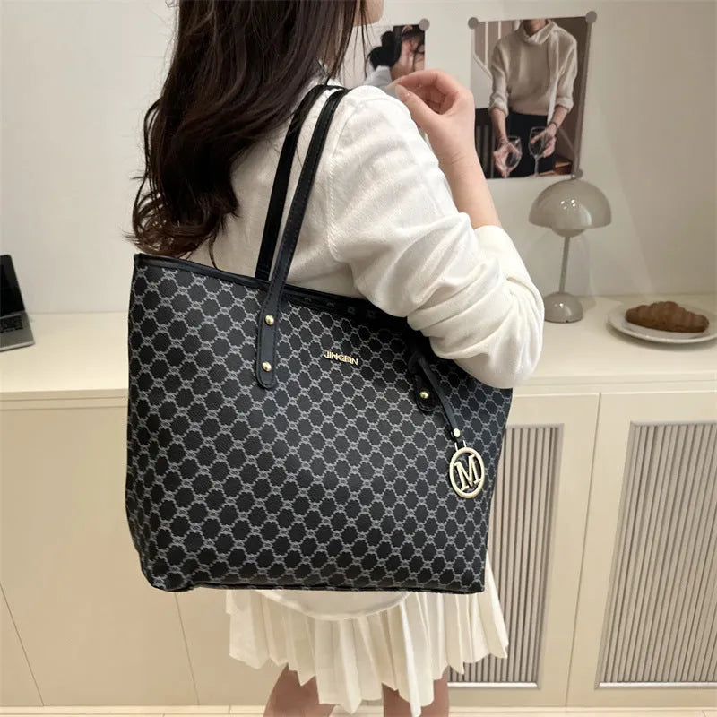 Soft PU leather ladies' shoulder bag in black showing contrast stitching and a top handle.