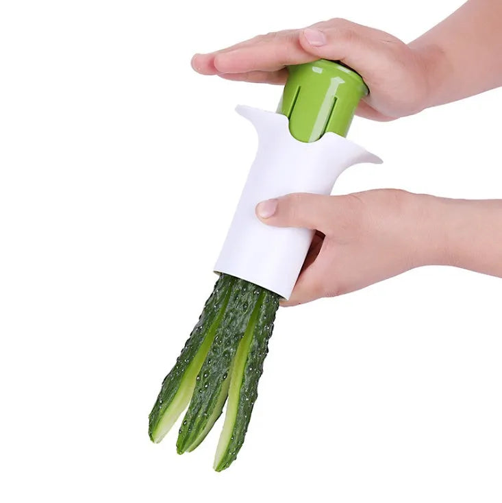 White plastic vegetable and fruit slicer with multiple stainless steel blades for cutting cucumbers, carrots, and strawberries.