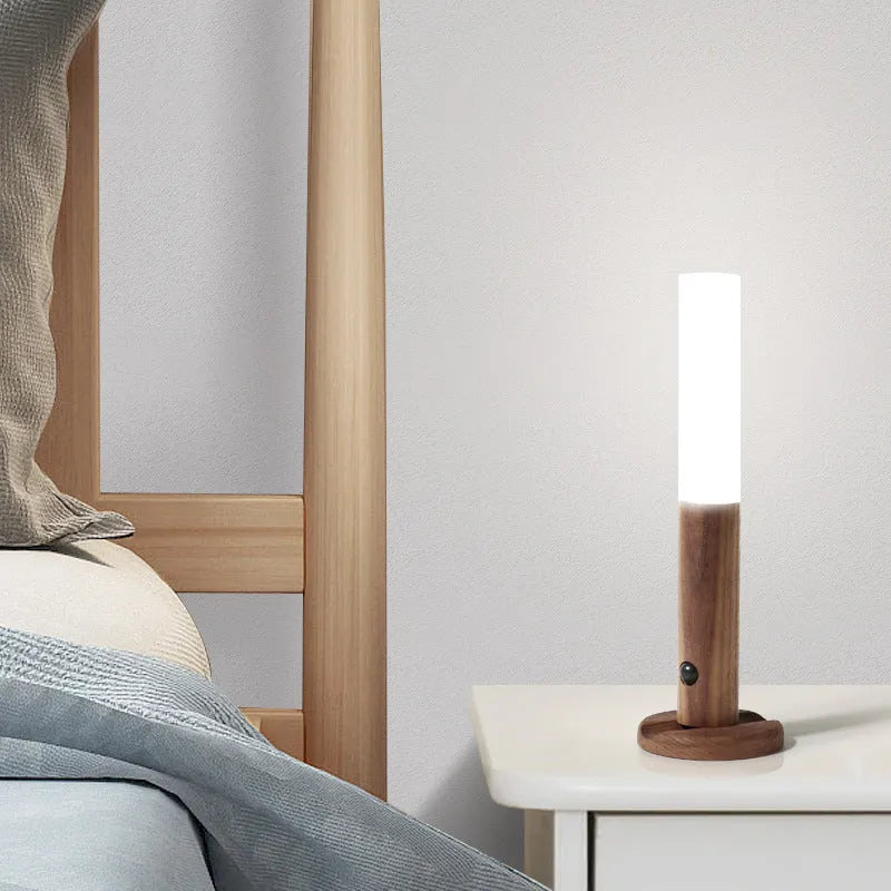 Smart sensor LED desk lamp in solid wood and acrylic, showing compact design beside a charging cable.