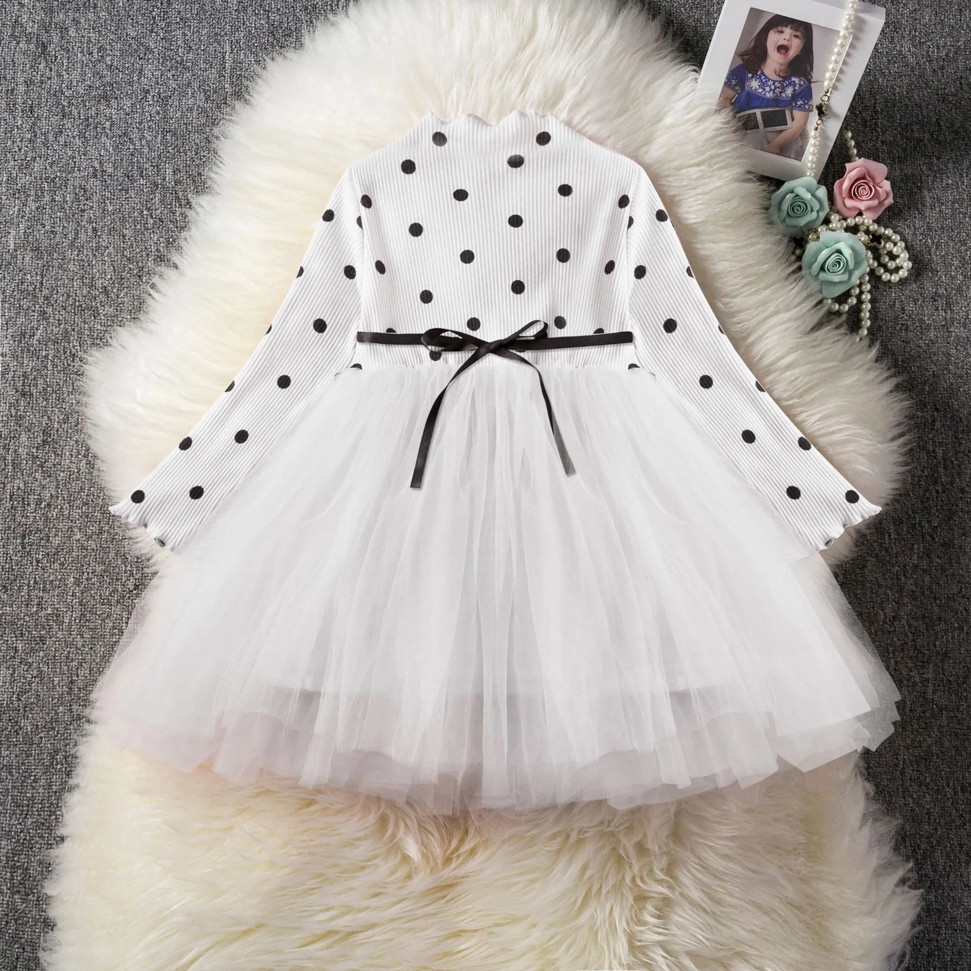 Baby girl in a long sleeve white lace tutu dress for a christening or birthday party.