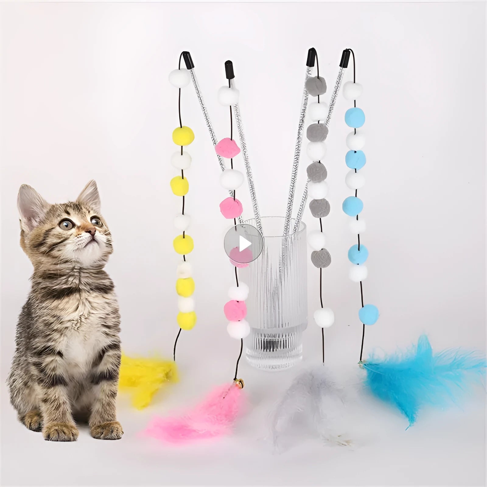 A blue acrylic cat teaser wand with pompon feathers and a bell, shown next to a grey and yellow version.