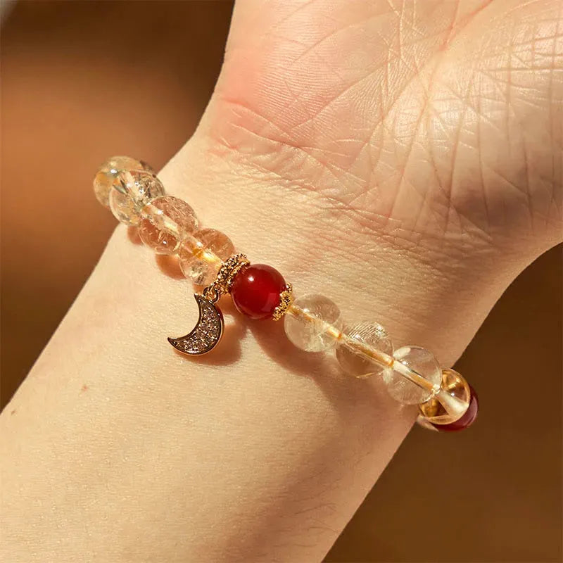 Citrine and red agate crystal moon boom bracelet for women on a white background.