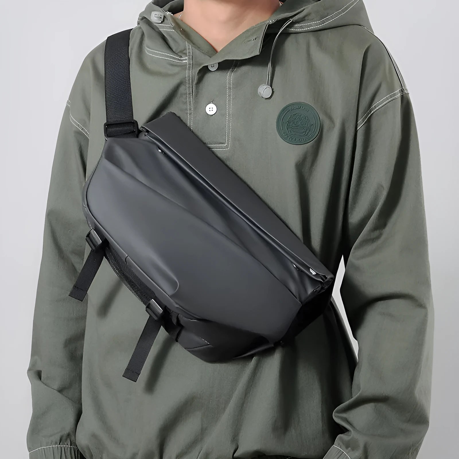 A grey medium-sized horizontal square PU crossbody bag for men, showing the shoulder strap and front zipper.