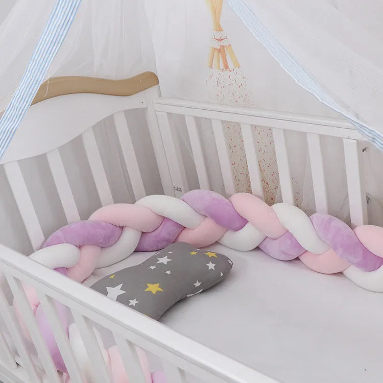 Bendable braid knot baby crib bumper in spandex velvet fabric on a white cot.