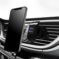 Black car phone holder clipped to vehicle air vent holding smartphone for navigation