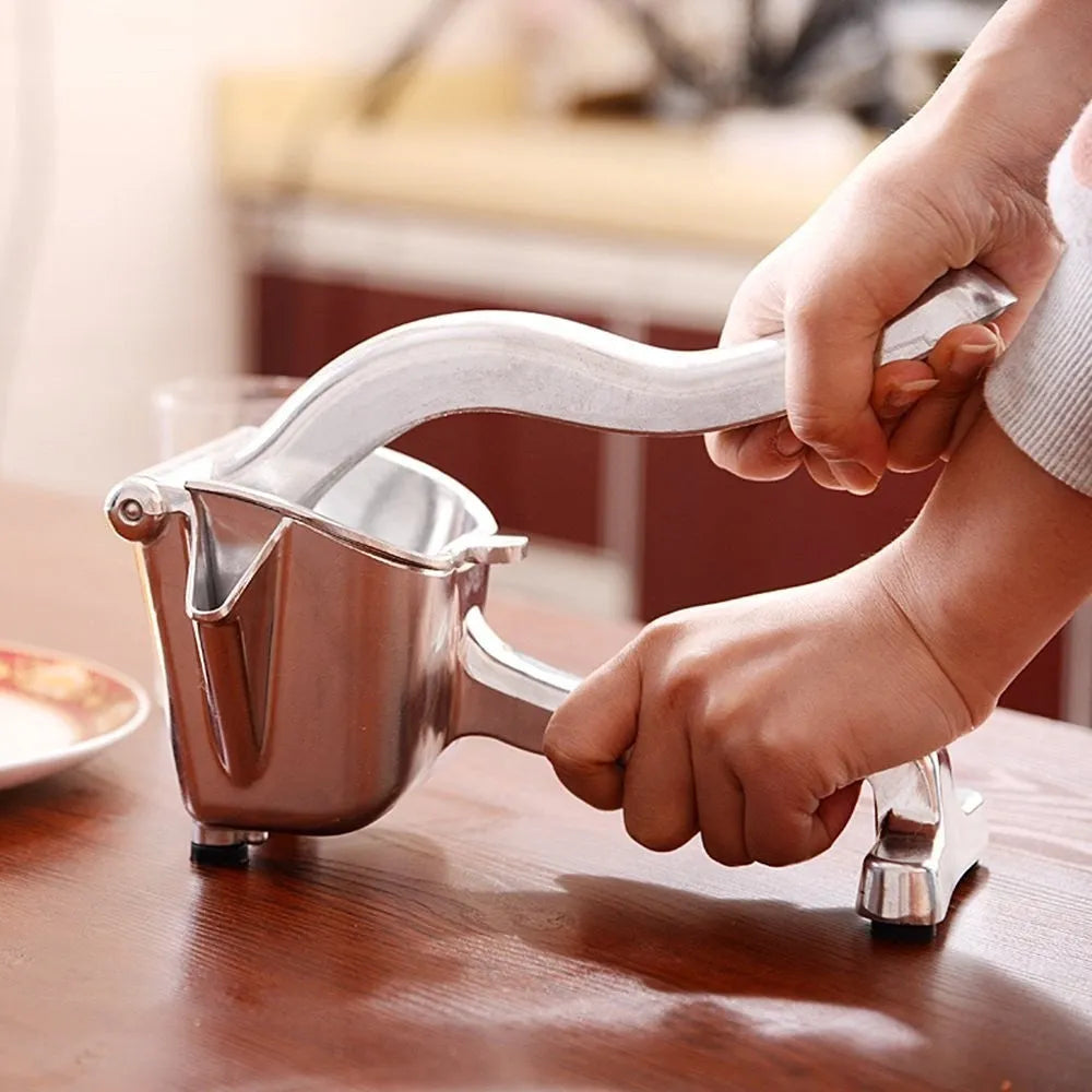 Silver heavy duty aluminium lemon squeezer with large bowl and steel lever on a kitchen counter.