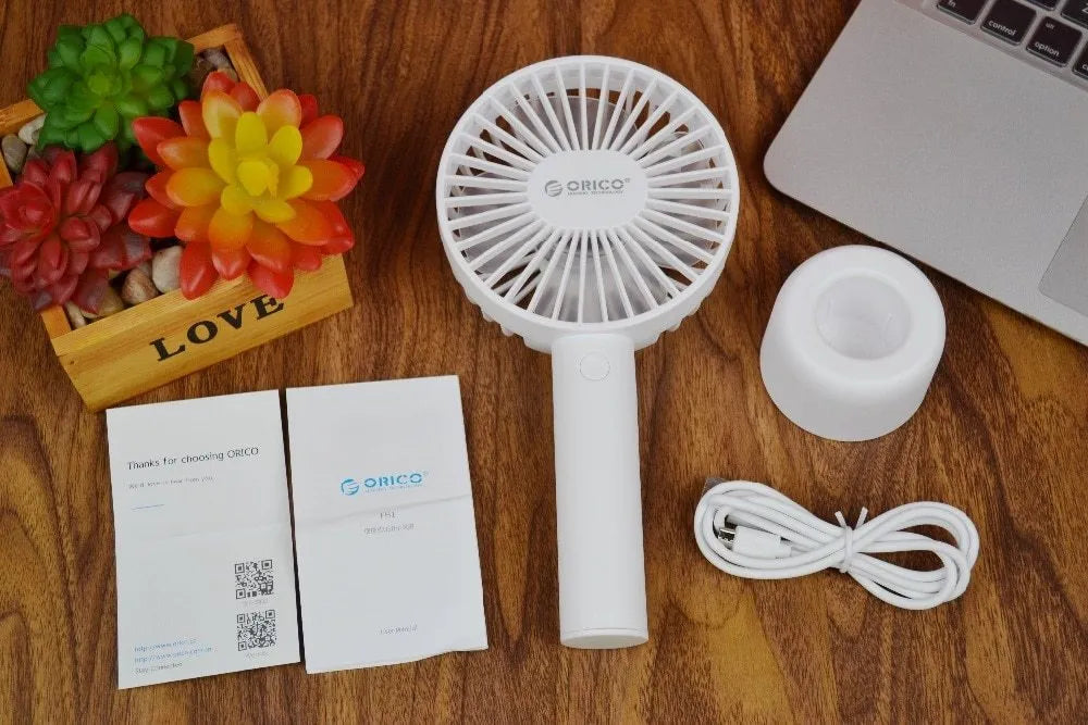 White ORICO FH1 portable USB rechargeable small fan on a desktop.