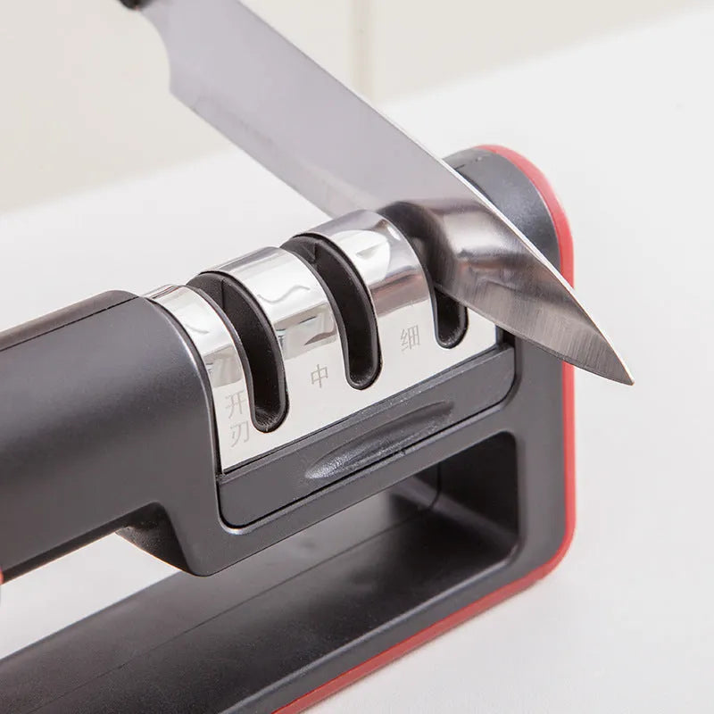 Black and red three-stage professional knife sharpener on a kitchen counter