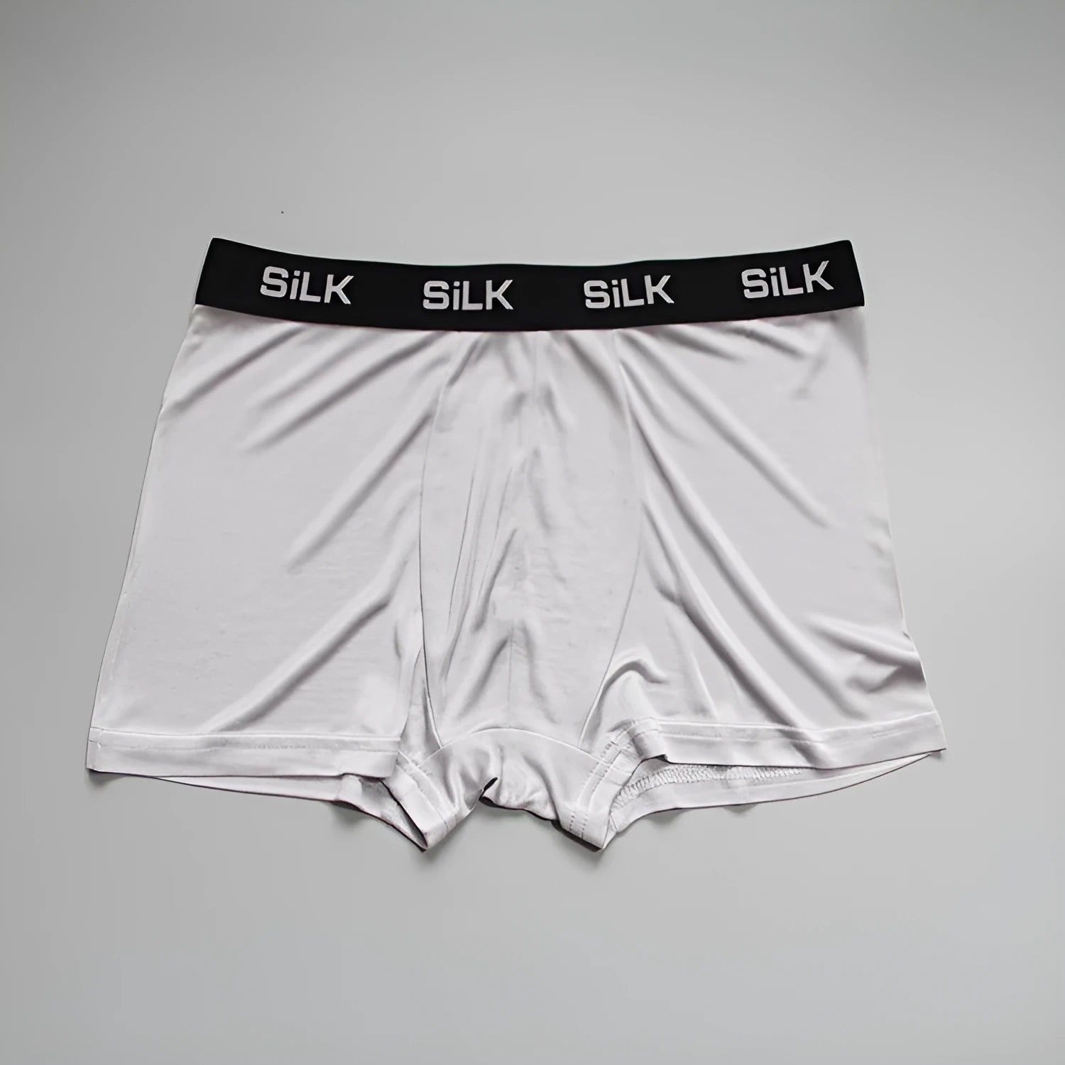 Men's loose-fit silk shorts in navy blue, shown on a mid-waist.