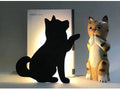 Cat-shaped LED night light with sound sensor on a wall, emitting warm yellow light.
