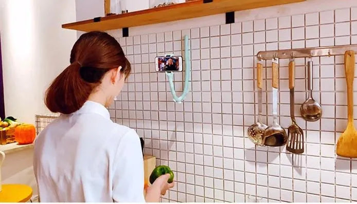 Black flexible lazy bracket mobile phone holder with long arm and suction cup base on a desktop