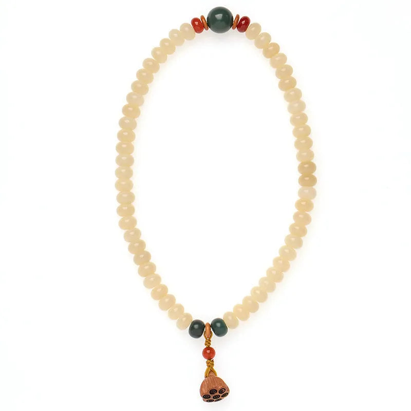 Cream topaz wooden bodhi root bracelet with flat round beads on a wrist.