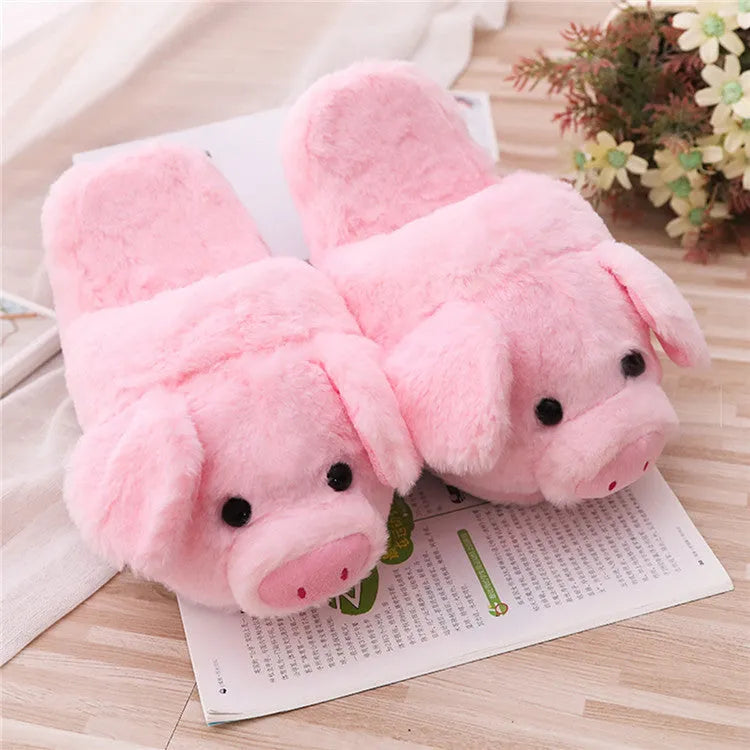 Pink pig-shaped plush floor slippers with soft filling on a plain background.