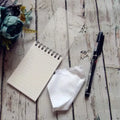 A6 spiral notebook with PP cover, pen, and rag on a surface