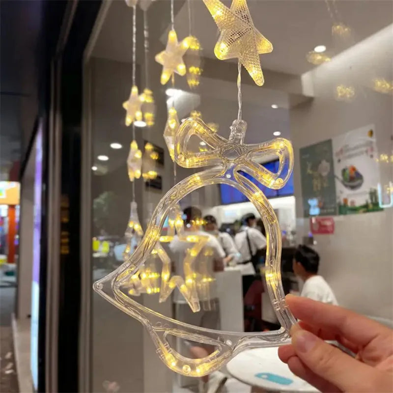 Three Christmas LED light ornaments with suction cups hanging on window