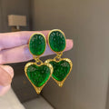 Oval heart-shaped alloy stud earrings with silver pleated edge, shown in purple, red, green, and yellow/white colour options.