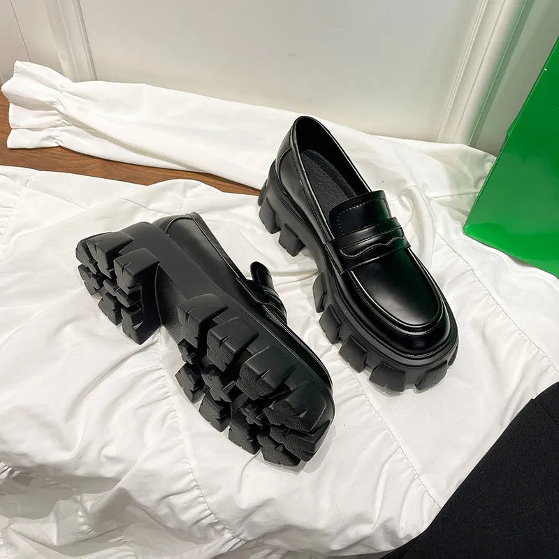 British style wide-fit loafers in patent leather with a muffin base heel and rubber sole.