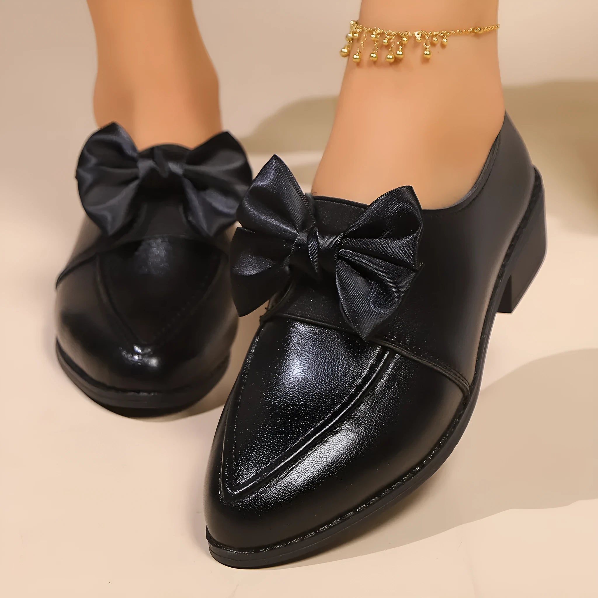 Women's simple leather-look flat shoes with a decorative bow, shown in slip-on style with a rubber sole.