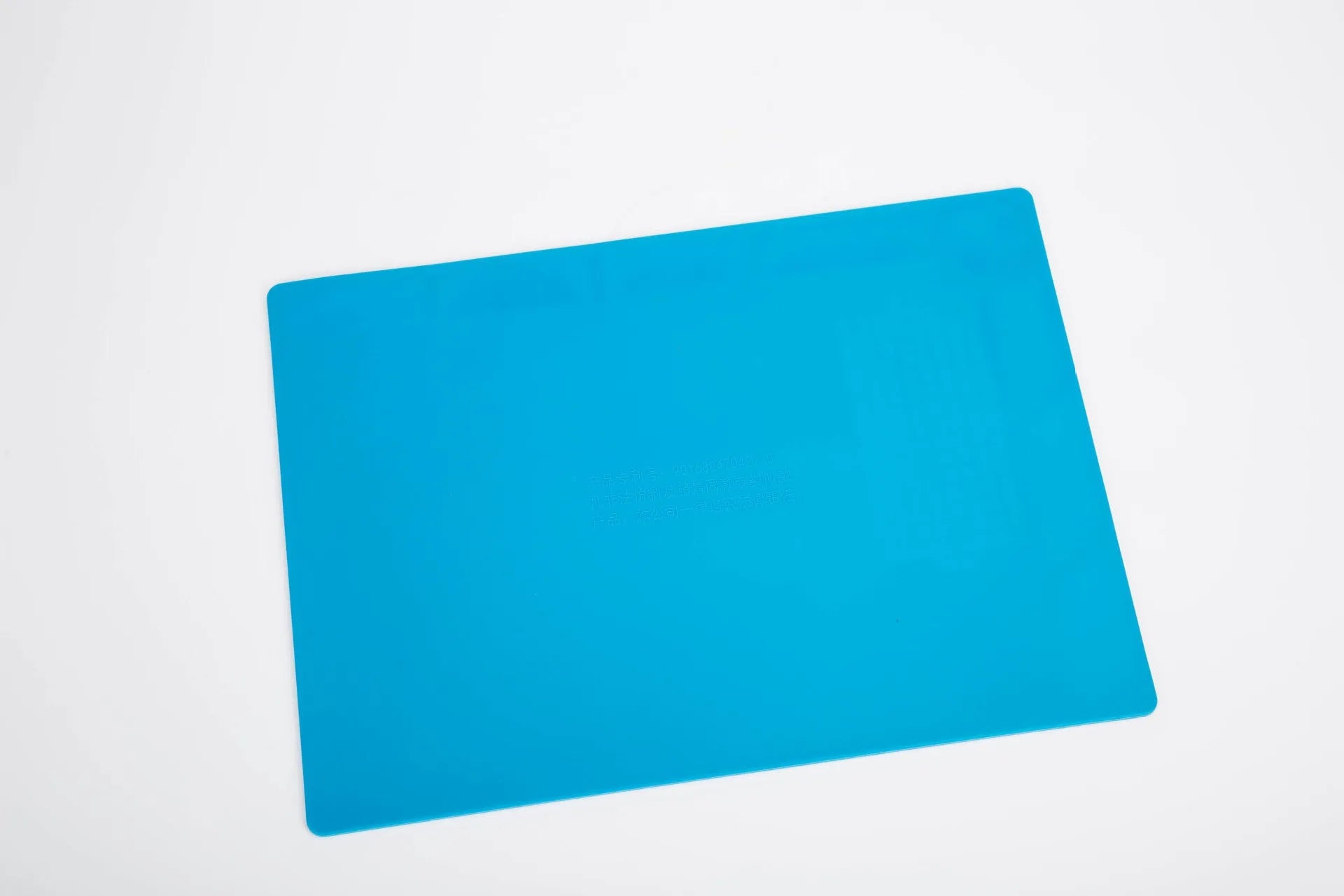 Blue silicone watch repair desk mat on a workbench, showing non-slip surface for watch components.