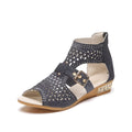 Women's beige sandals with back zipper closure and wedge heel on wooden floor