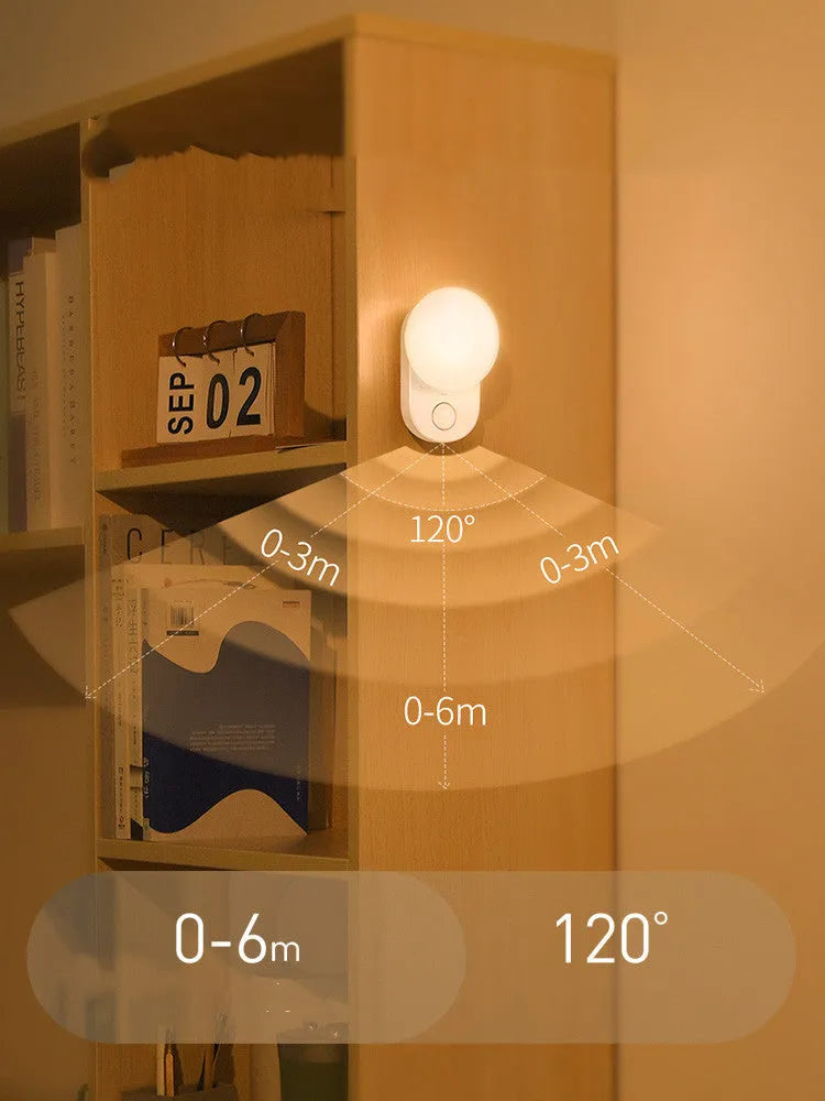 White Baseus rechargeable motion sensor night light on a bedside table.